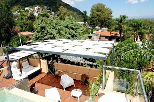 a patio with a white canopy and chairs on a balcony at Rincón de Paz Apart & Loft Suite Boutique - Adults Only in Villa Carlos Paz