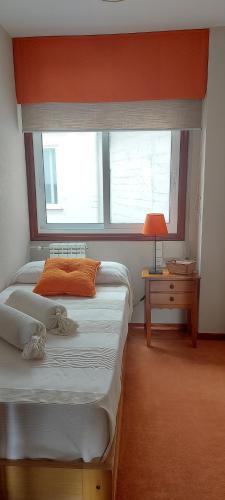 a bedroom with two beds and a window at Casa das Camelias in Vigo