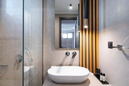 a bathroom with a toilet and a glass shower at Olia Thassos - Luxury Apartments in Limenas