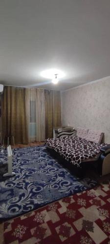 a bedroom with a bed and a patterned carpet at Bishkek 72 in Bishkek