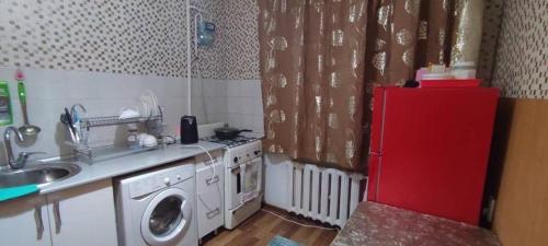 a kitchen with a sink and a red refrigerator at Bishkek 72 in Bishkek