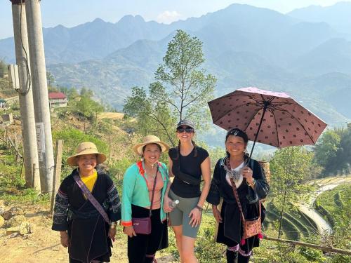 a group of women standing on a hill with an umbrella at Hmong Eco Villas in Sa Pa