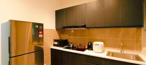 a kitchen with a sink and a refrigerator at Kulai d putra suites beside ioiMall near JPO and Airport in Kulai