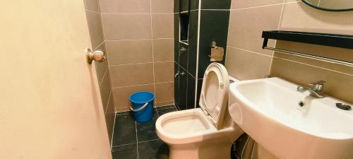a small bathroom with a toilet and a sink at Kulai d putra suites beside ioiMall near JPO and Airport in Kulai