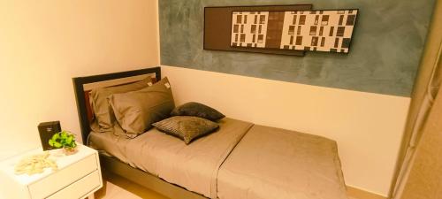 a small bed in a room with a picture on the wall at Kulai d putra suites beside ioiMall near JPO and Airport in Kulai