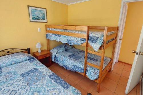 a bedroom with two bunk beds and a bed at Cabañas Las Flores - Barrio residencial La Herradura in Coquimbo