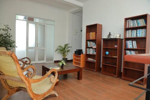 a living room with a chair and book shelves at The Paddy in Kottawa