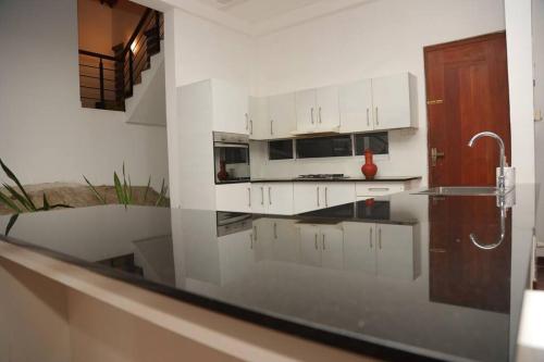 a kitchen with white cabinets and a counter top at Home immersed in nature in Kottawa