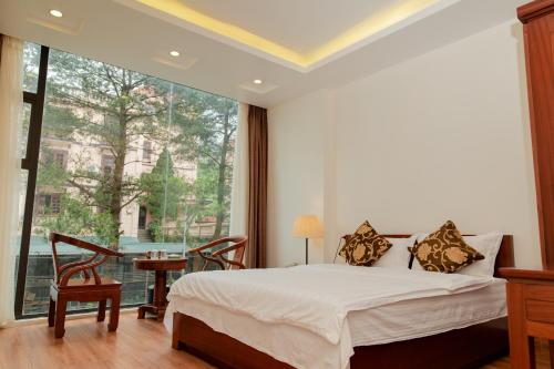 - une chambre avec un lit et une grande fenêtre dans l'établissement Eden Tam Dao Hotel - Lovely Hotel in Tam Dao, à Tam Ðảo