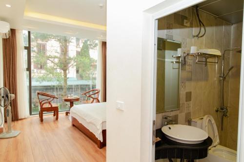 1 dormitorio con 1 cama y baño con lavamanos en Eden Tam Dao Hotel - Lovely Hotel in Tam Dao, en Tam Ðảo