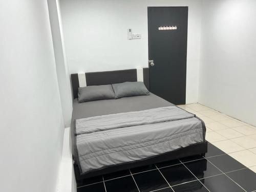 a small bed in a room with a black door at K SUITES HOTEL in Chabang Tiga
