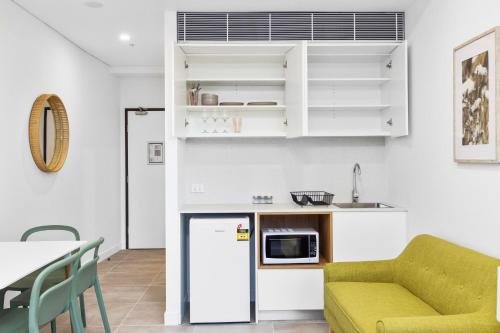 a kitchen and living room with a couch and a table at Arthur Hotel Bondi Junction no reception and house keeping no sofa bed in Sydney
