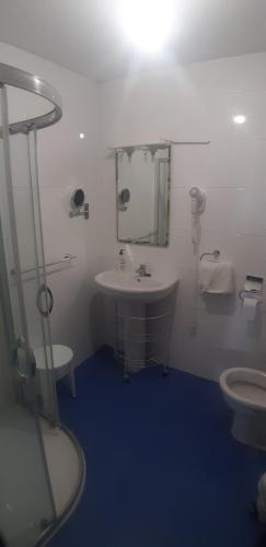a white bathroom with a sink and a toilet at Hotel Rural La Curva Ribadesella in Ribadesella