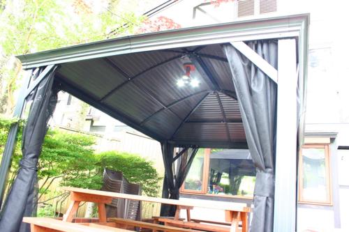 awning over a table with an umbrella on it at Pension Marieペンションマリエ in Yamanakako
