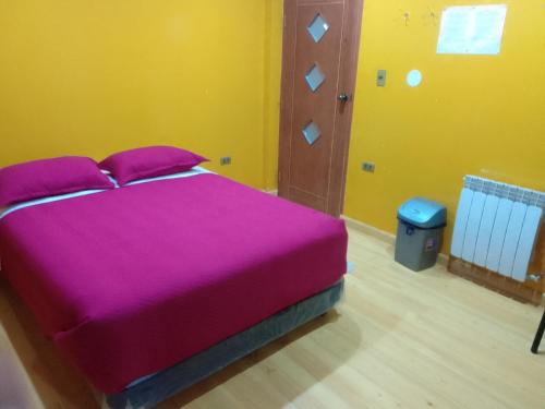 um quarto com uma cama grande e um cobertor roxo em Hostal Sin fronteras em Uyuni