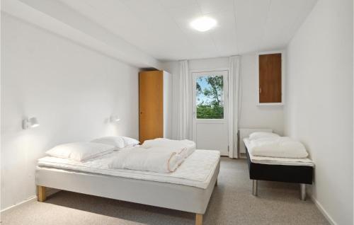 Habitación blanca con 2 camas y ventana en Cozy Home In Brovst With Kitchen, en Brovst