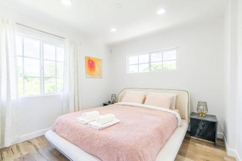 a bedroom with a large bed with a pink blanket at New luxury entertaining house with Pool Spa Sauna Tesla charger Pets in Los Angeles