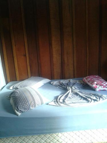 a bed with two pillows on top of it at Pousada Margareth in Ilha do Mel