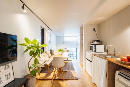 cocina y sala de estar con mesa larga y sillas en RiriLeo Koenji, en Tokio