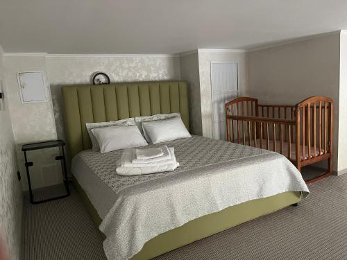 ボロヴォエにあるСовременные и уютные аппартаментыのベッドルーム1室(ベッド1台、ベビーベッド1台付)
