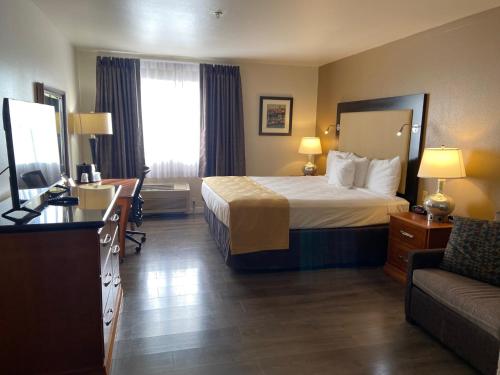 a hotel room with a bed and a couch at Toppenish Inn and Suites in Toppenish
