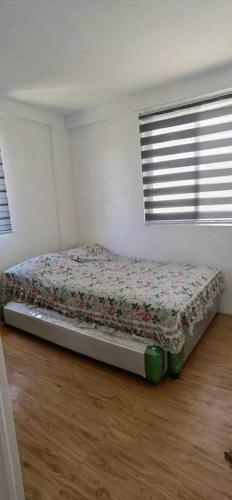 - une chambre avec un lit dans une pièce dotée d'une fenêtre dans l'établissement Camella Staycation, à Butuan