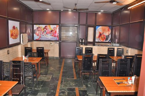 Hotel Sidhartha Walking Distance From TajMahal في آغْرا: غرفة طعام مع طاولات وكراسي خشبية