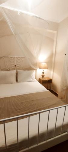 una camera da letto con un letto bianco con baldacchino di Persefoni 's hause 1 a Nea Kalikratia