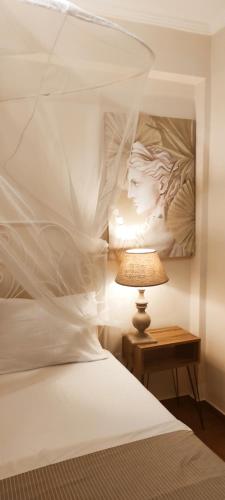 a bedroom with a white bed and a lamp at Persefoni 's hause 1 in Nea Kalikratia