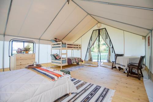 a bedroom in a tent with a bed and a desk at Family Glamping Tent in Cassville