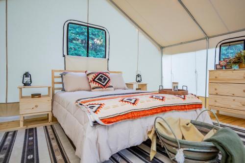 a bedroom with a bed in a room with windows at Roaring River Luxury Glamping #4 in Cassville