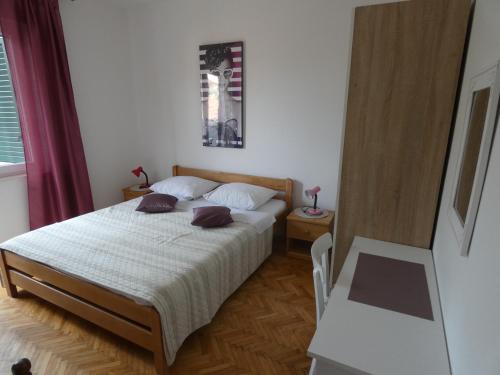 1 dormitorio con 1 cama con 2 almohadas en Apartman Žarko, en Tkon