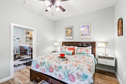 a bedroom with a bed and a table with flowers on it at The Anchor Beach House in Galveston