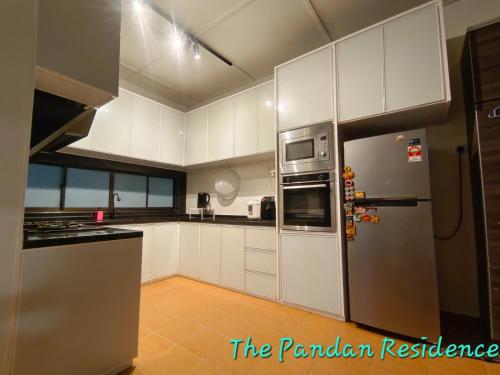a kitchen with white cabinets and a stainless steel refrigerator at The Pandan Residence in Kuantan