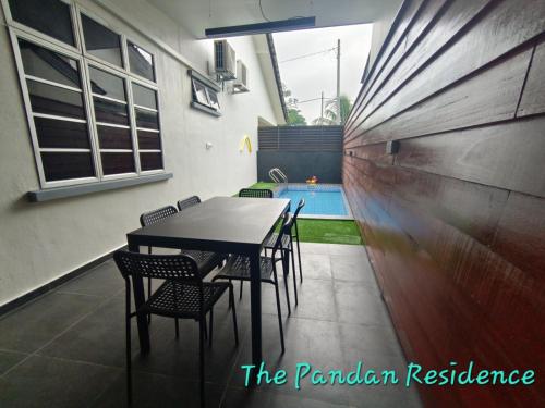 a dining area with a table and chairs and a swimming pool at The Pandan Residence in Kuantan
