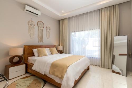 Un dormitorio con una cama grande y una ventana grande. en Hills House Villa by Globalstay - Jimbaran x Balangan x GWK, en Jimbaran