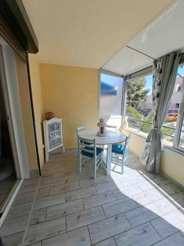 une salle à manger avec une table et des chaises et une fenêtre dans l'établissement Bel appartement, proche plage les sablettes, à La Seyne-sur-Mer