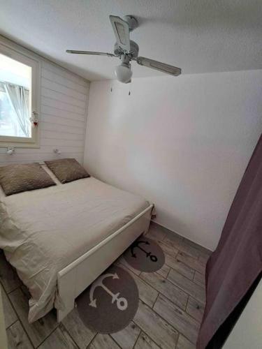 une chambre avec un lit et un ventilateur de plafond dans l'établissement Bel appartement, proche plage les sablettes, à La Seyne-sur-Mer
