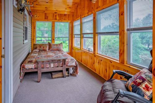 een slaapkamer met 2 bedden en een tafel en ramen bij Fish~N~Moor Cabin in Hammond