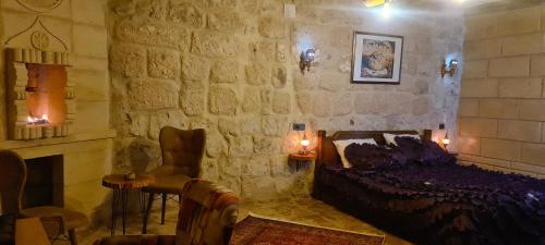 a bedroom with a bed and a stone wall at Cappadoo 