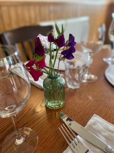 a table with a vase with purple flowers in it at The Gordon Arms Restaurant with Rooms in Yarrow