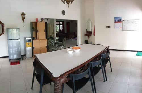 una mesa y sillas en una habitación con cocina en Villa Edelweis, en Pasuruan