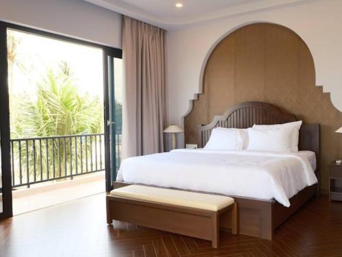 a bedroom with a large bed and a large window at Villa C62 - Private Swimming Pool 100M2 - In Stunning Sea Front Location in Mui Ne