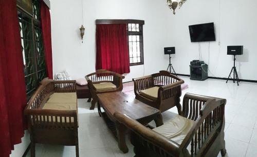 ein Wohnzimmer mit einem Holztisch und Stühlen in der Unterkunft Villa Edelweis in Pasuruan