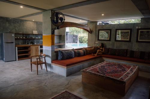 a woman sitting on a couch in a living room at Mangroove Bay Boutique Hostel in Banyuwedang