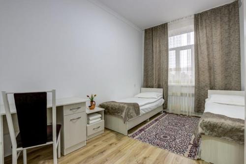 a small room with two beds and a television at Olive hotel Kochkor in Kochkor