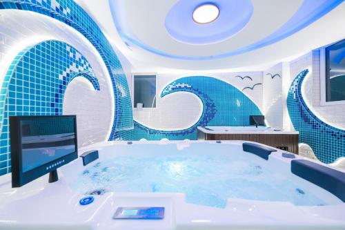 uma banheira num quarto com azulejos azuis em Hotel Kanjon Zrmanje em Obrovac