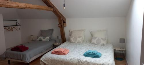 a bedroom with two beds with towels on them at Chambres d'hôtes La Babinerie in Saint-Léonard-de-Noblat