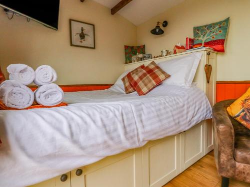 a bedroom with a bed with towels on it at The Herdsman Luxury Shepherds Hut in Barnoldswick