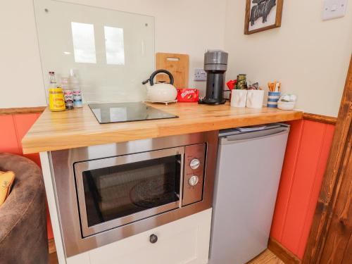 a kitchen with a counter top with a microwave at The Herdsman Luxury Shepherds Hut in Barnoldswick